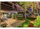 Covered patio with dining set, chairs, potted plants, rug, and greenery in a serene backyard setting at 853 Morning Sun Ct, Las Vegas, NV 89110