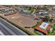 An aerial view of an equestrian center with a horse track, stables, tennis courts, pool, and grassy common areas at 853 Morning Sun Ct, Las Vegas, NV 89110