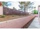 Backyard featuring a retaining wall and xeriscaping with small plants at 930 High Plains Dr, Henderson, NV 89002