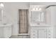 Bathroom featuring double sinks, white cabinets, and a door with privacy curtain at 930 High Plains Dr, Henderson, NV 89002