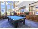 Spacious game room with a pool table, comfortable seating, and large windows, ideal for entertainment at 9921 Woodhouse Dr, Las Vegas, NV 89134