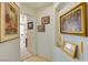 Hallway decorated with decorative wall art leading to bedroom with ceiling fan and bright natural light at 9921 Woodhouse Dr, Las Vegas, NV 89134