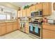 Functional kitchen featuring light wood cabinetry, stainless steel appliances, and granite countertops at 9921 Woodhouse Dr, Las Vegas, NV 89134