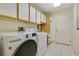 Well-organized laundry room features white washer and dryer, ample storage, and tiled floors at 9921 Woodhouse Dr, Las Vegas, NV 89134