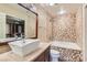 Elegant bathroom featuring a vessel sink, decorative tile work, and a luxurious bathtub at 10159 Tumbling Tree St, Las Vegas, NV 89183