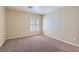Simple bedroom with beige walls, carpeted flooring, and window with shade at 10159 Tumbling Tree St, Las Vegas, NV 89183