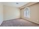 Cozy, carpeted bedroom with a unique arched window providing natural light at 10159 Tumbling Tree St, Las Vegas, NV 89183