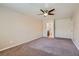 Spacious, carpeted bedroom featuring a ceiling fan and a view into the adjacent bathroom at 10159 Tumbling Tree St, Las Vegas, NV 89183