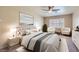 Cozy bedroom featuring a ceiling fan, ensuite chairs, and a large window at 10159 Tumbling Tree St, Las Vegas, NV 89183