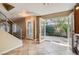 Light-filled dining room has tile floors, a glass back door, modern staircase, and warm tan walls at 10159 Tumbling Tree St, Las Vegas, NV 89183
