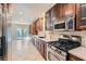 Well-lit kitchen features stainless steel appliances, wooden cabinets, and tile flooring at 10159 Tumbling Tree St, Las Vegas, NV 89183