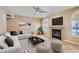 Stylish living room with a corner fireplace, arch window, modern ceiling fan and contemporary decor at 10159 Tumbling Tree St, Las Vegas, NV 89183