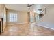 Open-concept living room featuring tile flooring, a ceiling fan, and a staircase at 10159 Tumbling Tree St, Las Vegas, NV 89183