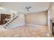 Bright and open living room with tile flooring, modern ceiling fan and access to the staircase at 10159 Tumbling Tree St, Las Vegas, NV 89183
