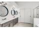 Bathroom featuring double sinks with round mirrors, white cabinets, and tiled floors at 1124 Coral Rainbow Ave, Las Vegas, NV 89123