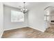 Dining room with wood-look tile floors, light fixture, large window, and neutral color scheme at 1124 Coral Rainbow Ave, Las Vegas, NV 89123
