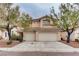 Two-story home featuring a two-car garage, landscaped front yard, and warm exterior at 1124 Coral Rainbow Ave, Las Vegas, NV 89123