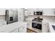 Modern kitchen featuring white cabinets, stainless steel appliances, and a quartz countertop island at 1124 Coral Rainbow Ave, Las Vegas, NV 89123