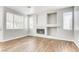 Bright living room with wood-look floors, a tiled fireplace, and large windows at 1124 Coral Rainbow Ave, Las Vegas, NV 89123