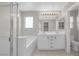 Bright bathroom featuring double sinks, a soaking tub, and a glass-enclosed shower with tiled flooring at 11273 Accademia Ct, Las Vegas, NV 89141