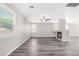 Bright living room featuring gray floors, ceiling fan, and fireplace at 11273 Accademia Ct, Las Vegas, NV 89141