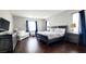 Comfortable main bedroom with dark wood floors, and a seating area with a white loveseat at 12273 Catanzaro Ave, Las Vegas, NV 89138