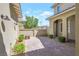 Beautiful brick paved patio featuring a high privacy wall, landscaping, and sconce lighting at 12273 Catanzaro Ave, Las Vegas, NV 89138