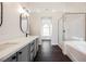 Bright bathroom featuring double sinks, a soaking tub, and glass-enclosed shower at 1601 Iguana St, Pahrump, NV 89048