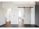 Hallway featuring a sliding barn door, hardwood floors, and access to other rooms at 1601 Iguana St, Pahrump, NV 89048