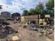 Backyard filled with debris and overgrown vegetation, showcasing property's potential at 1655 N Gateway Rd, Las Vegas, NV 89115