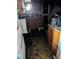 Fire-damaged kitchen features a sink, wooden cabinets, and dark, water-stained floors at 1655 N Gateway Rd, Las Vegas, NV 89115