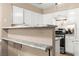 Kitchen area with a breakfast bar, white cabinets, stainless steel appliances, and updated countertops at 2040 Bavington Dr # D, Las Vegas, NV 89108