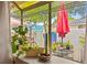 Window view that overlooks a patio with potted plants, a red umbrella, and a glimpse of the neighborhood at 2040 Bavington Dr # D, Las Vegas, NV 89108