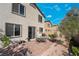 Lovely backyard showcasing a brick patio, well-maintained landscaping, and access to the home through a sliding glass door at 2332 Mundare Dr, Henderson, NV 89002