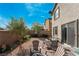 The backyard includes a brick patio, mature trees, desert landscaping, and comfortable seating for relaxing and entertaining at 2332 Mundare Dr, Henderson, NV 89002