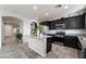 Well-lit kitchen with dark cabinetry, stainless steel appliances, and granite countertops at 2332 Mundare Dr, Henderson, NV 89002