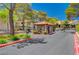 View of the community entrance gate with mature trees and manicured landscaping offering security and curb appeal at 2451 N Rainbow Blvd # 1066, Las Vegas, NV 89108
