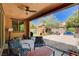 Inviting covered patio with ceiling fan and charming outdoor seating, overlooking a beautiful backyard at 2544 Sable Ridge St, Henderson, NV 89044
