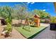 Beautiful backyard with play structure, artificial turf, and brick pavers, creating a fun outdoor space at 2544 Sable Ridge St, Henderson, NV 89044