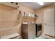 Functional laundry room features modern appliances, shelving and storage space for convenience at 2544 Sable Ridge St, Henderson, NV 89044