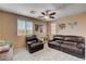 Cozy living room with ceiling fan, carpeted floors and leather sofa and chair at 2544 Sable Ridge St, Henderson, NV 89044