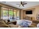 Bright living room with tile flooring, fan, neutral walls, backyard view, and comfortable seating arrangement at 2544 Sable Ridge St, Henderson, NV 89044