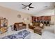 Spacious living room with fan, tile flooring, and two couches, adjacent to the open kitchen and dining area at 2544 Sable Ridge St, Henderson, NV 89044