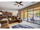 Open-concept living room featuring tile flooring, a ceiling fan, access to the backyard, and views of the kitchen at 2544 Sable Ridge St, Henderson, NV 89044