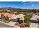 A scenic aerial view of the property showcasing the house, surrounding neighborhood, and distant mountains at 2587 Grizzly Park Ct, Henderson, NV 89052