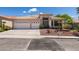Charming single-story home featuring desert landscaping, a spacious driveway, and a two-car garage at 2587 Grizzly Park Ct, Henderson, NV 89052