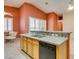 Well-equipped kitchen featuring wooden cabinets, granite countertops, stainless sink, and a breakfast nook bathed in natural light at 2587 Grizzly Park Ct, Henderson, NV 89052