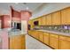 Bright kitchen showcasing wood cabinets, granite countertops, stainless steel appliances and tile flooring at 2587 Grizzly Park Ct, Henderson, NV 89052