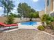 Lush backyard showcasing a kidney-shaped pool, desert landscaping, and lounging area, ideal for relaxation at 2736 Huber Heights Dr, Las Vegas, NV 89128