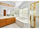 Bright bathroom featuring a soaking tub by a window and a separate shower with gold trim at 2736 Huber Heights Dr, Las Vegas, NV 89128